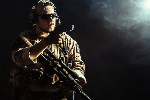 Soldat des forces spéciales avec fusil dans l'obscurité