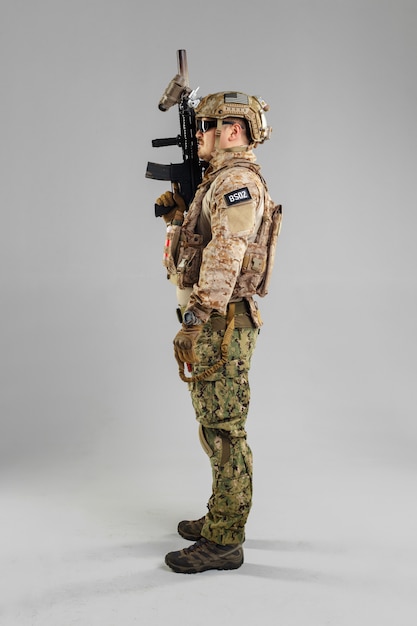 Soldat des forces spéciales avec fusil sur fond blanc.