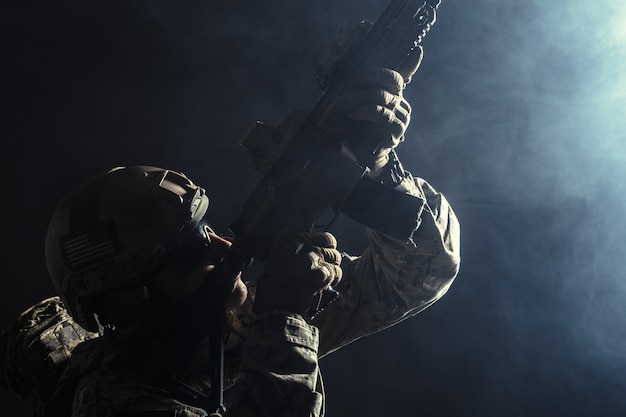 Soldat des forces spéciales avec fusil sur fond sombre