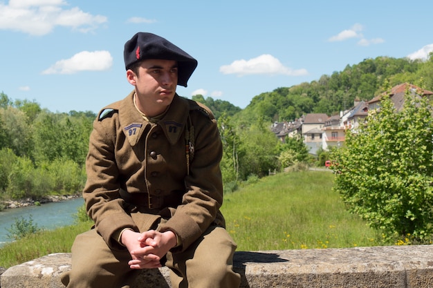 Soldat français en uniforme des années 1940, assis en plein air