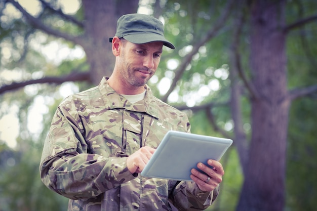 Soldat en regardant tablet pc dans le parc