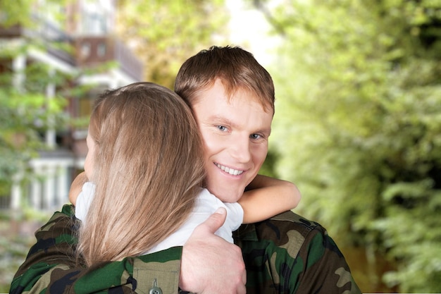 Soldat souriant avec une petite fille debout sur fond