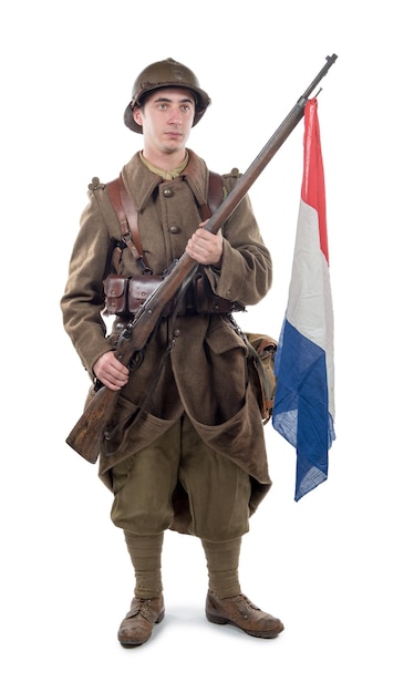 Photo soldat tenant un drapeau et un fusil alors qu'il se tient contre un fond blanc