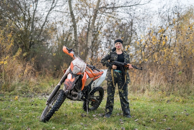 Soldat en tenue de camouflage avec fusil et moto sale