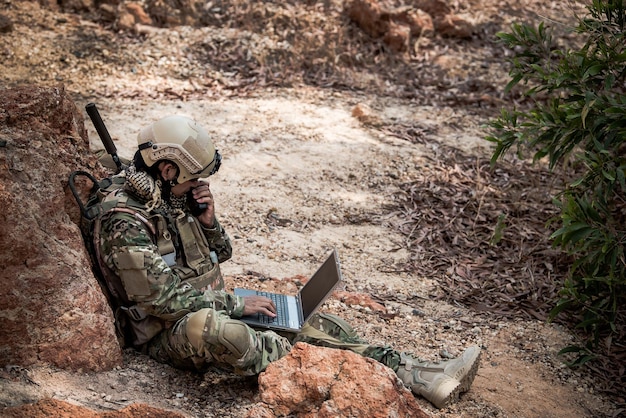 Soldats des forces spéciales sur les guerres dans le désertThaïlandeUn soldat de l'armée utilise un ordinateur portable pour voir la carte avec le satelliteUtilisation de la radio pour la communication pendant l'opération militaire