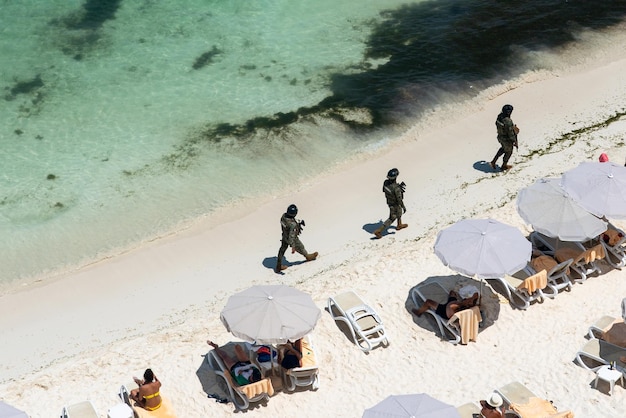 Soldats de la marina de l'armée mexicaine patrouillant sur la plage de cancun