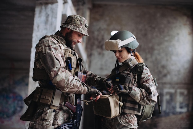 Soldats ukrainiens entièrement équipés et armés vérifiant leur équipement tout en faisant une pausexA