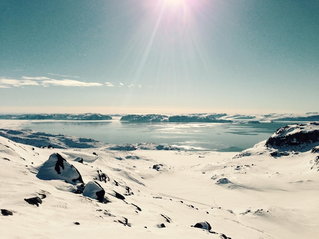 Photo le soleil brille sur le paysage couvert de neige.