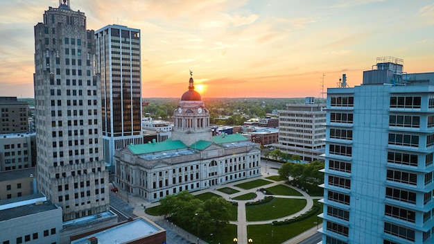 Le soleil doré s'élève au-dessus de l'horizon derrière le palais de justice dans une vue aérienne du centre-ville de Fort Wayne