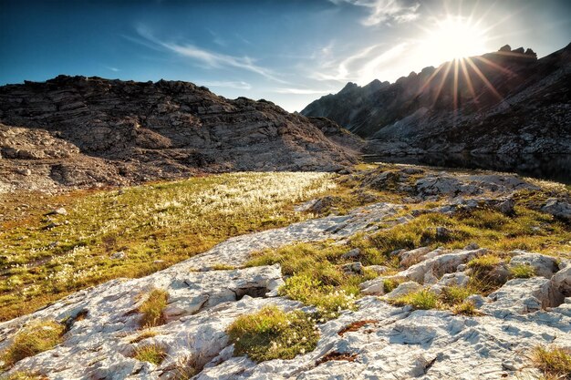 Le soleil sur le lac alpin entre les rochers