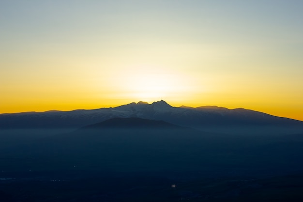 Le soleil se couche derrière la montagne