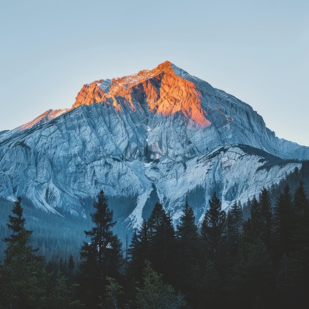 Le soleil se couche derrière un sommet de montagne enneigé