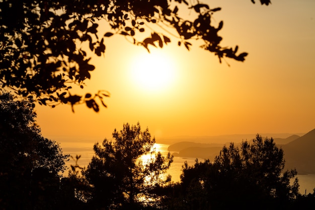 Photo le soleil se couche à l'horizon au coucher du soleil sur la mer ou l'océan. vagues de l'océan calme. ciel naturel aux couleurs chaudes. vue panoramique,