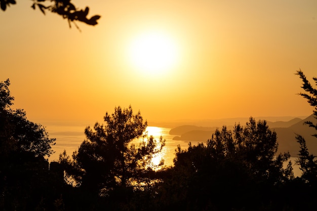 Le soleil se couche à l'horizon au coucher du soleil sur la mer ou l'océan. Vagues de l'océan calme. Ciel naturel aux couleurs chaudes. Vue panoramique,