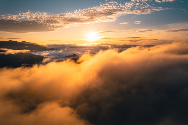 Le soleil se lève dans la brume et les montagnes le matin, brouillard du matin