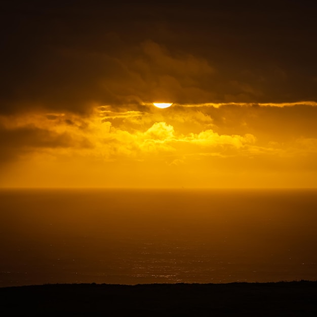 Soleil, sous les nuages dans un coucher de soleil doré sur la mer Cantabrique Asturies