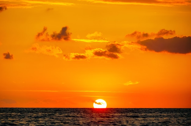 Le soleil a touché l&#39;horizon au coucher du soleil sur la mer