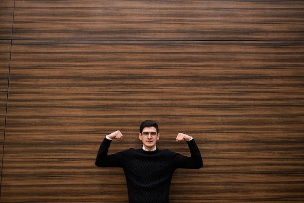 des solutions commerciales solides. stratégie de développement. homme d'entreprise de bureau montrant sa force avec un geste de la main. fond de mur de texture bois. rue à l'extérieur. notion d'espace libre