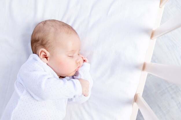 Sommeil sain d'un nouveau-né dans un berceau dans la chambre sur un lit en coton, portrait