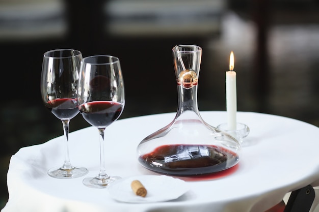 Un sommelier versant du vin rouge dans une carafe