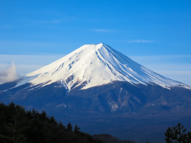 Photo sommet de la montagne fuji rempli de neige blanche et fond de ciel bleu dans la scène de la lumière du matin