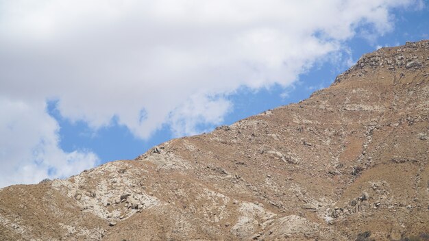 Photo sommet de la montagne avec quelques nuages ​​et ciel bleu clair