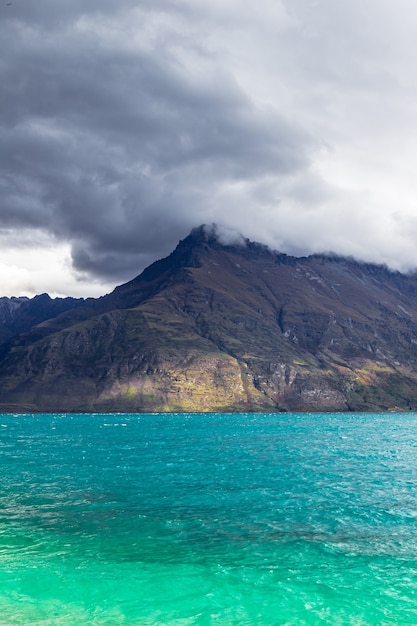 Les sommets des montagnes jusqu'aux nuages sur l'eau turquoise jour de pluie au lac Wakatipu Nouvelle-zélande