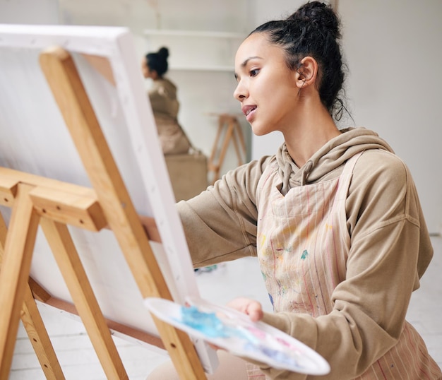 De son esprit à la toile. Prise de vue en grand angle d'une jolie jeune femme peignant sur une toile dans son studio.