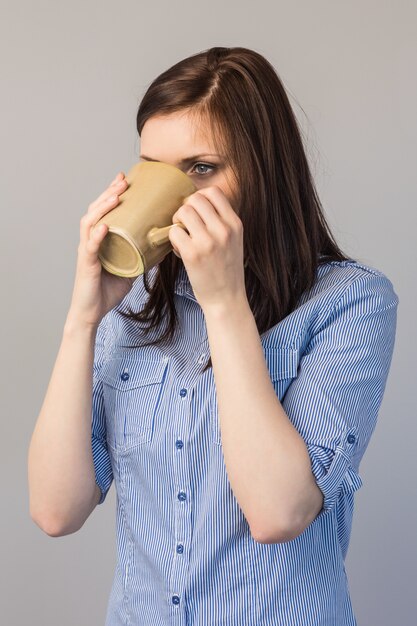 Songeuse jolie brune boire un café