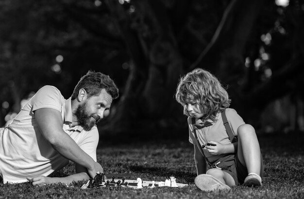 Photo sonplaying échecs avec père enfant jouant à un jeu de société avec parent