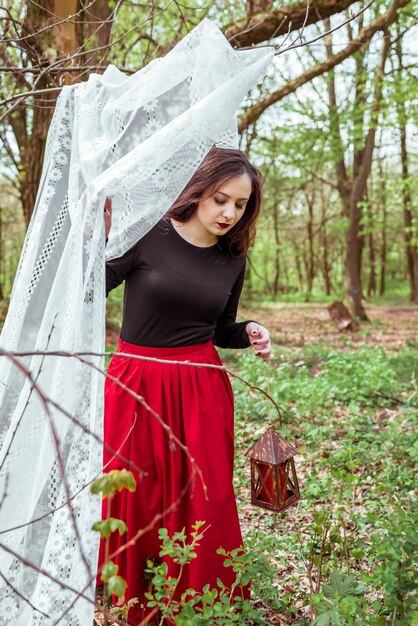 Sorcière dans la forêt avec une lanterne