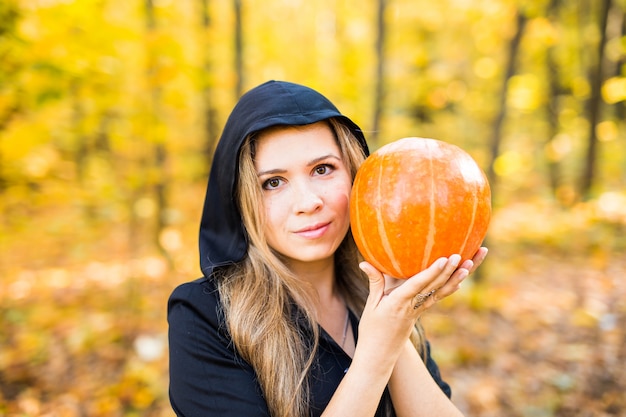 Sorcière d'Halloween avec citrouille dans une forêt. Halloween