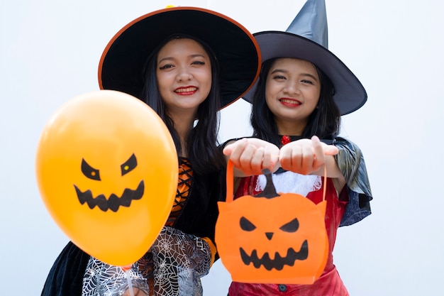 Sorcière d'Halloween et Dracula avec ballon et citrouille sur fond blanc.