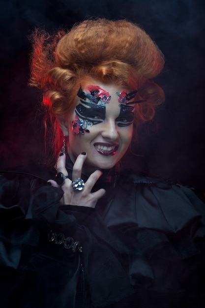 Sorcière rousse gothique. Femme noire. Maquillage artistique. Photo d'Halloween.