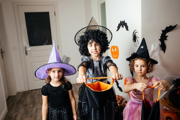 Sorcières de petites filles attendant des friandises d'halloween