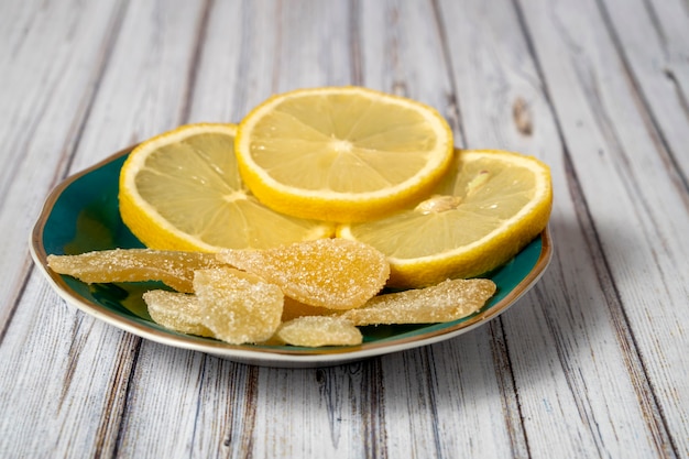 Photo soucoupe aux citrons et gingembre confit sur une table en bois. fermer