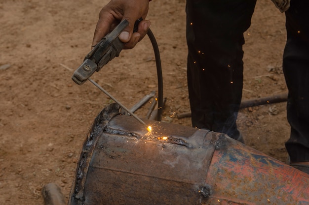 Soudeur soudant des tuyaux en métal sur un chantier de construction