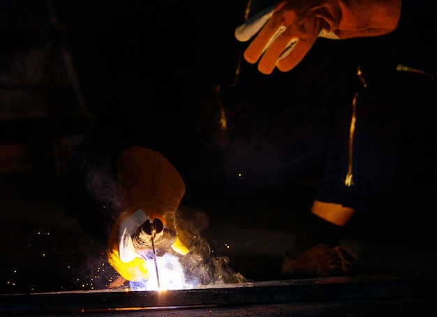 Le soudeur soude l'acier ensemble pour le rendre plus solide. Le travail produit des étincelles brillantes avec de la fumée, l'effet de la lumière et de la fumée lui donne une belle lumière bleue. L'arc est un domaine spécialisé qui nécessite des compétences.