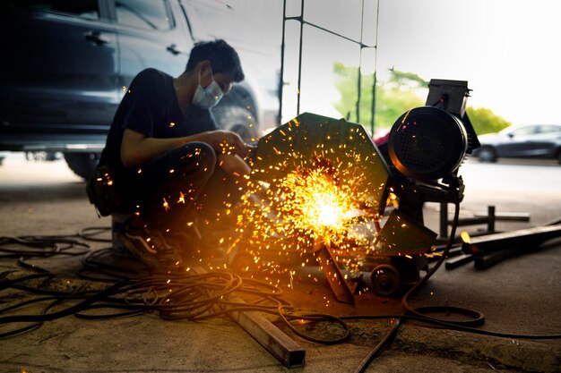 Le soudeur utilisait une pierre de broyage sur l'acier dans l'usine avec des étincelles.