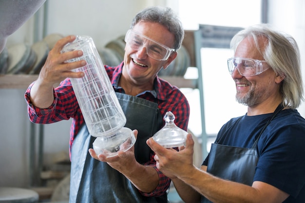 Souffleur de verre et un collègue à la recherche de verrerie