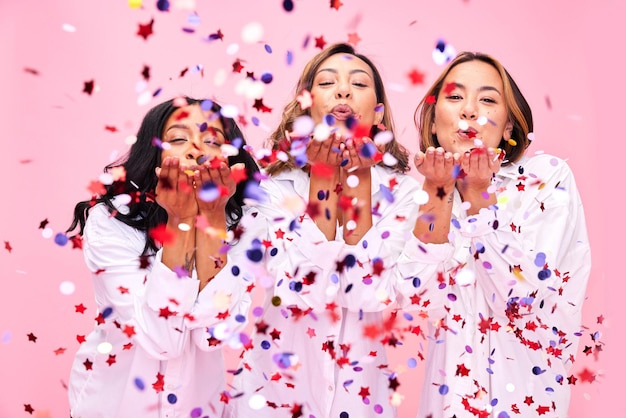 Soufflez des confettis et des portraits de femmes en studio pour la vente et la remise de sous-vêtements de célébration Diversité de beauté et femmes sur fond rose pour les cosmétiques, soins naturels de la peau et bien-être