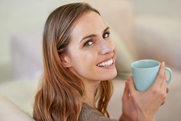 Souhaitez-vous une tasse Portrait d'une jolie femme buvant du café assis sur le canapé