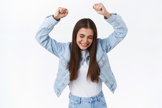 Soulagé joyeuse femme heureuse faire chamion danse levant les mains en l'air triomphant gagnant prix ou prix célébrant la victoire souriant ravi d'obtenir une promotion ou une approbation fond blanc