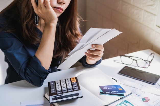 A souligné la jeune femme vérifiant les factures, les taxes, le solde du compte bancaire et le calcul des dépenses dans le salon à la maison