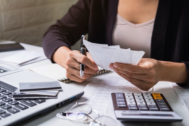 A souligné la jeune femme vérifiant les factures, les taxes, le solde du compte bancaire et le calcul des dépenses dans le salon à la maison