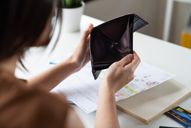 A souligné les jeunes femmes asiatiques ont des problèmes financiers assis portefeuille ouvert pas d'argent pour payer la dette de facture de carte de crédit