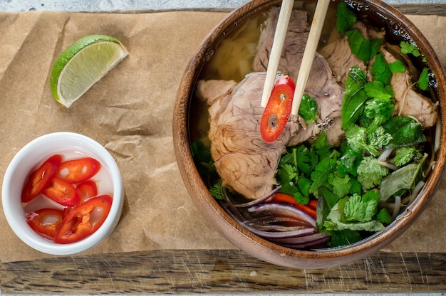 Soupe asiatique dans un bol en bois, soupe pho bo