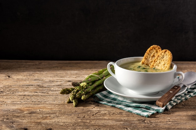 Soupe d'asperges fraîches sur une table en bois