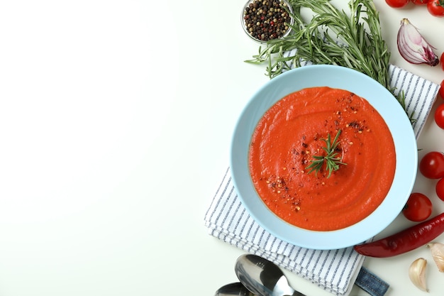 Soupe au gaspacho et ingrédients sur fond blanc