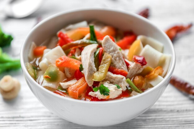 Soupe au poulet et aux nouilles dans un bol sur une table en bois libre